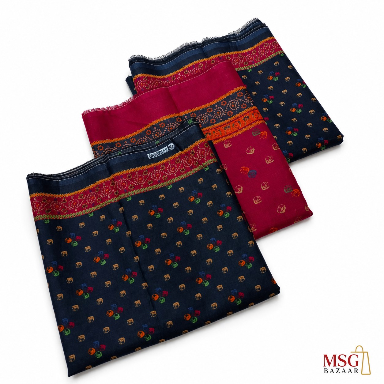 Three folded pieces of printed fabric laid out on a white background, featuring a navy base with small multicolor motifs and a wide red border with gold detailing. A small MSG BAZAAR logo appears in the bottom right corner.