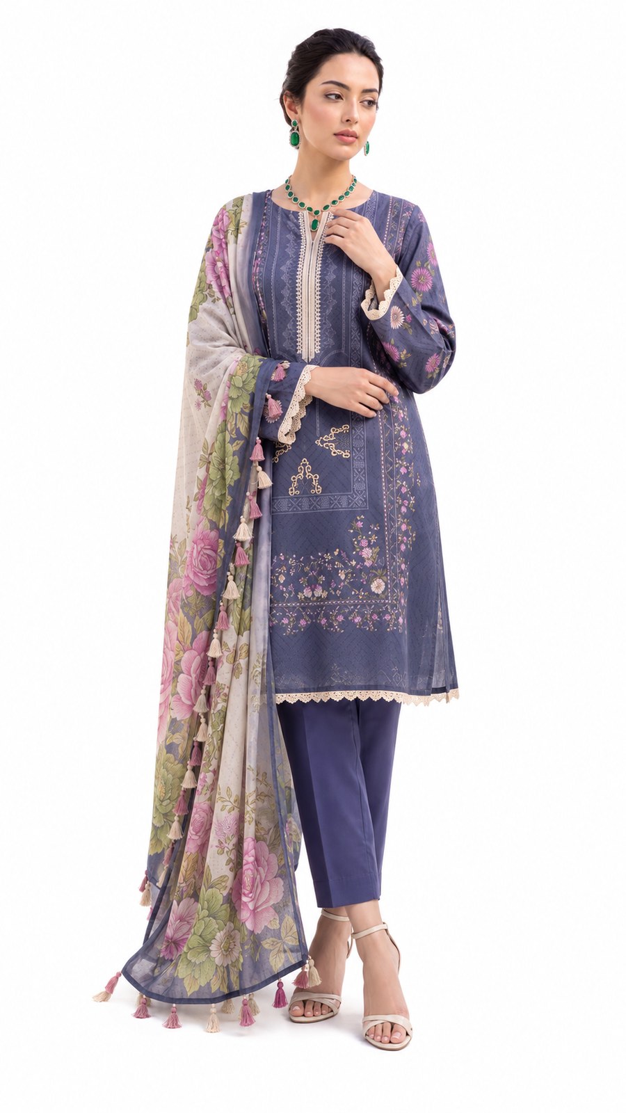 A woman modeling a traditional South Asian outfit consisting of a dusty blue kurta with floral embroidery, matching blue pants, and a beige dupatta with pink floral prints and tassels, set against a plain white background.