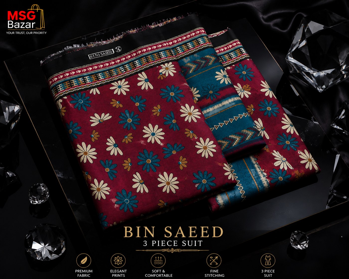 A 3-piece suit set from MSC Bazar named 'Bin Saeed', featuring a deep red kurta with cream and blue floral prints, paired with teal and navy patterned trousers. The set is styled in a luxury black presentation box with decorative black silk fabric and clear crystal props, with product details and features displayed at the bottom.