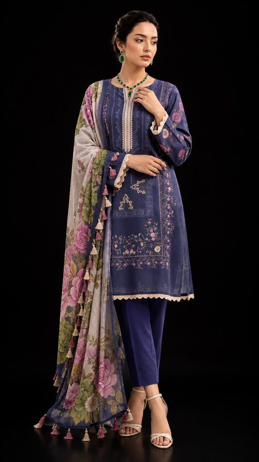 A woman modeling a traditional three-piece salwar kameez suit in navy blue with floral embroidery, paired with a multicolor floral printed dupatta and navy trousers, set against a solid black background.
