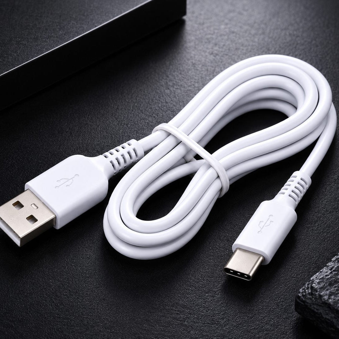 A white USB-A to USB-C charging cable coiled on a dark textured surface.