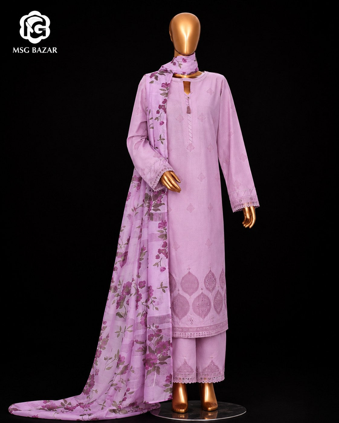 A lavender purple 3-piece salwar kameez suit set displayed on a gold mannequin against a black background. The set includes a kurta with floral embroidery, matching trousers, and a dupatta.