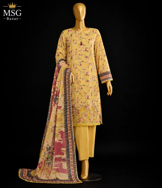 A yellow floral printed salwar kameez suit with matching yellow trousers and a beige dupatta featuring pink and multicolor patterns, displayed on a gold mannequin against a black background. The MSG Bazar logo is visible in the top left corner.